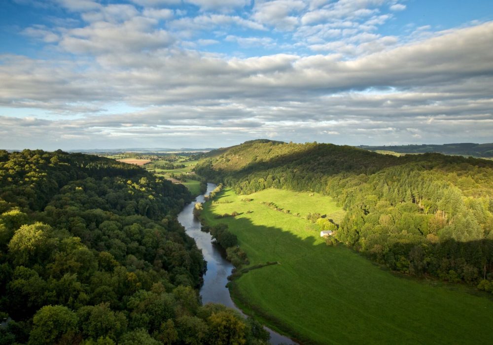 a view of Symonds Yat Rock with the sun shining from behind over looking the wye valley.